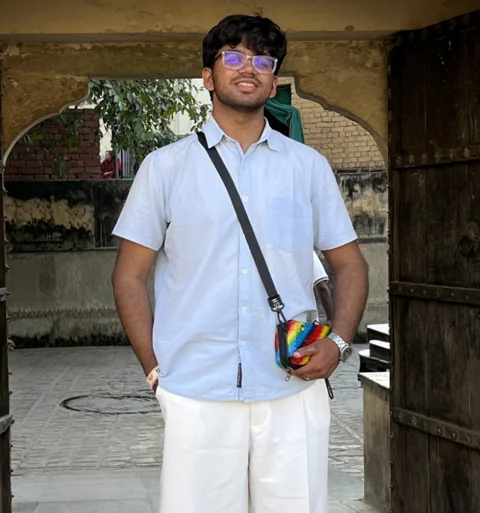 Vaibhav Singh standing in a white shirt with a shoulder bag
